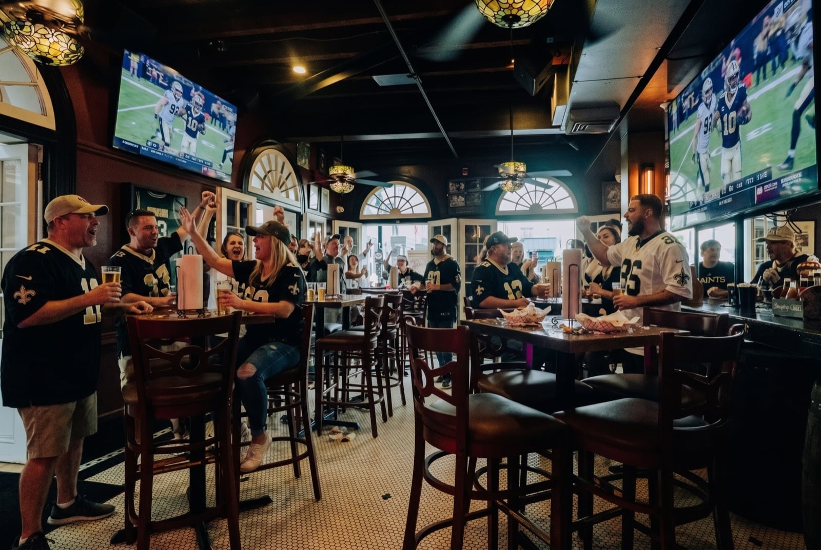 Fans in jerseys roaring at the screens